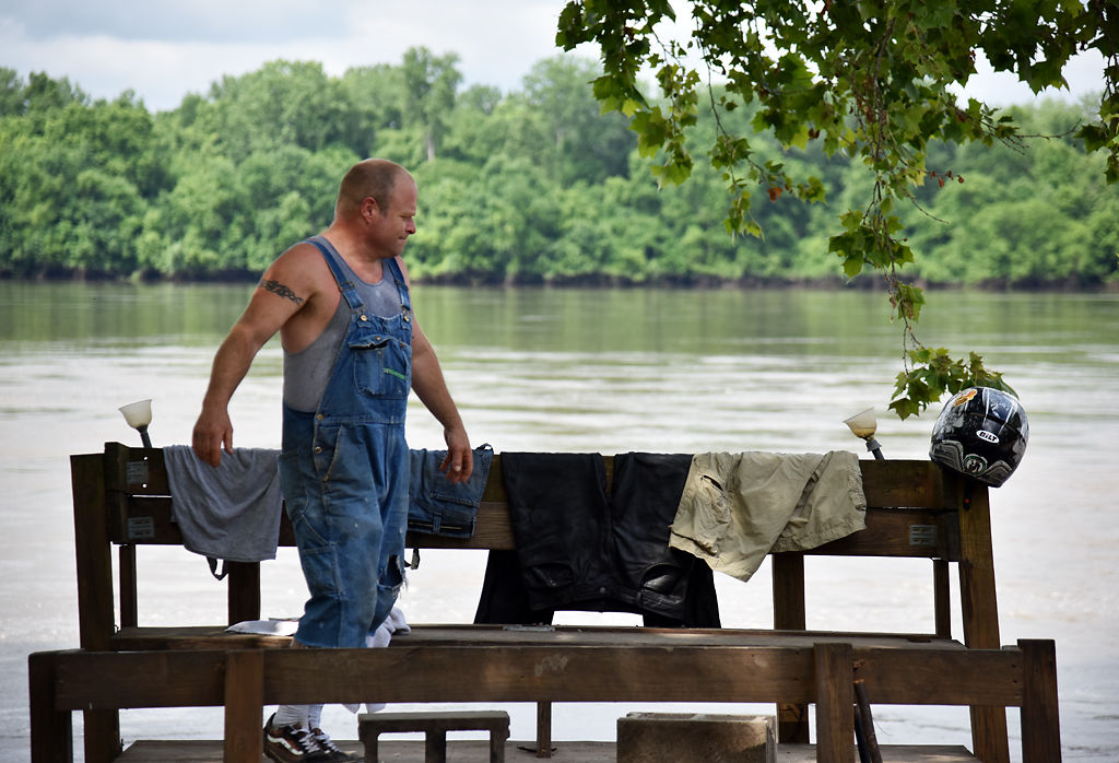 Rodney Brown lays clothes that were left behind during the flood out to dry